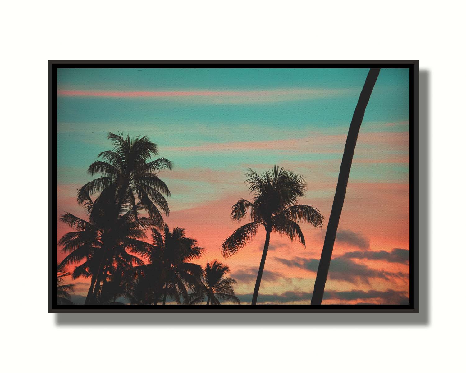 A photograph of Hawaiʻian palm trees, sihouetted against a sunset sky in orange, pink, and blue. Printed on canvas in a float frame.