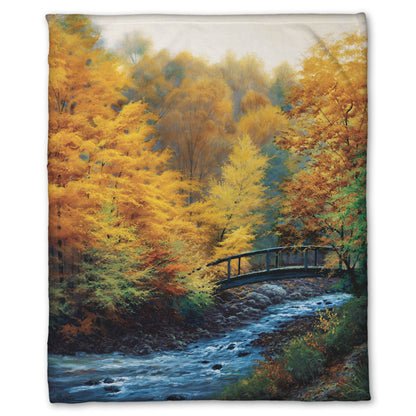 Coral fleece blanket designed with a painting of a forest stream, passing under an arched bridge. The trees are changing to yellow and orange for fall.