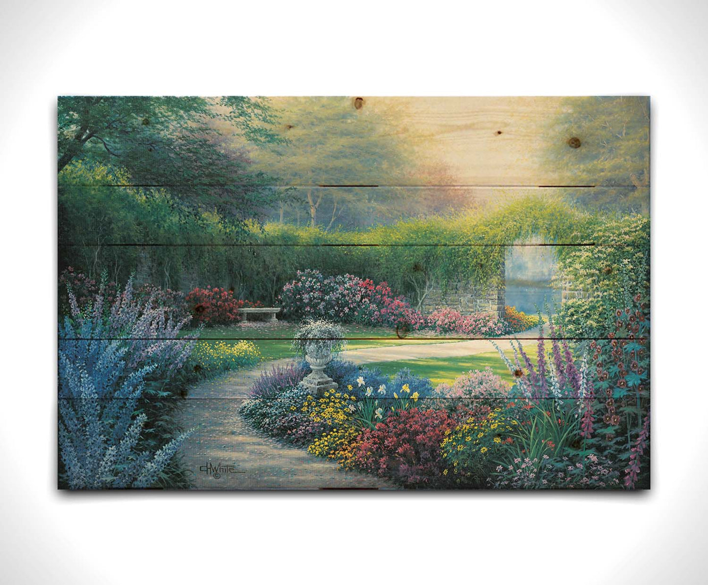 A painting of a serene path through a garden filled with bushes of flowers bathed in a gentle light. Printed on a wood pallet.