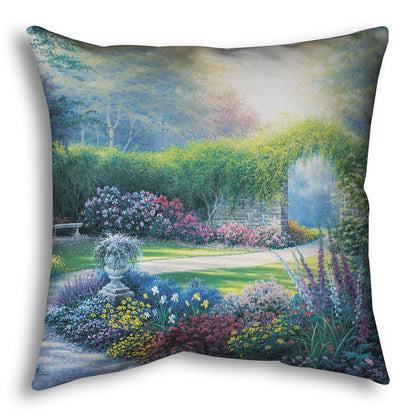 A throw pillow designed with a painting of a serene path through a garden filled with bushes of flowers bathed in a gentle light.