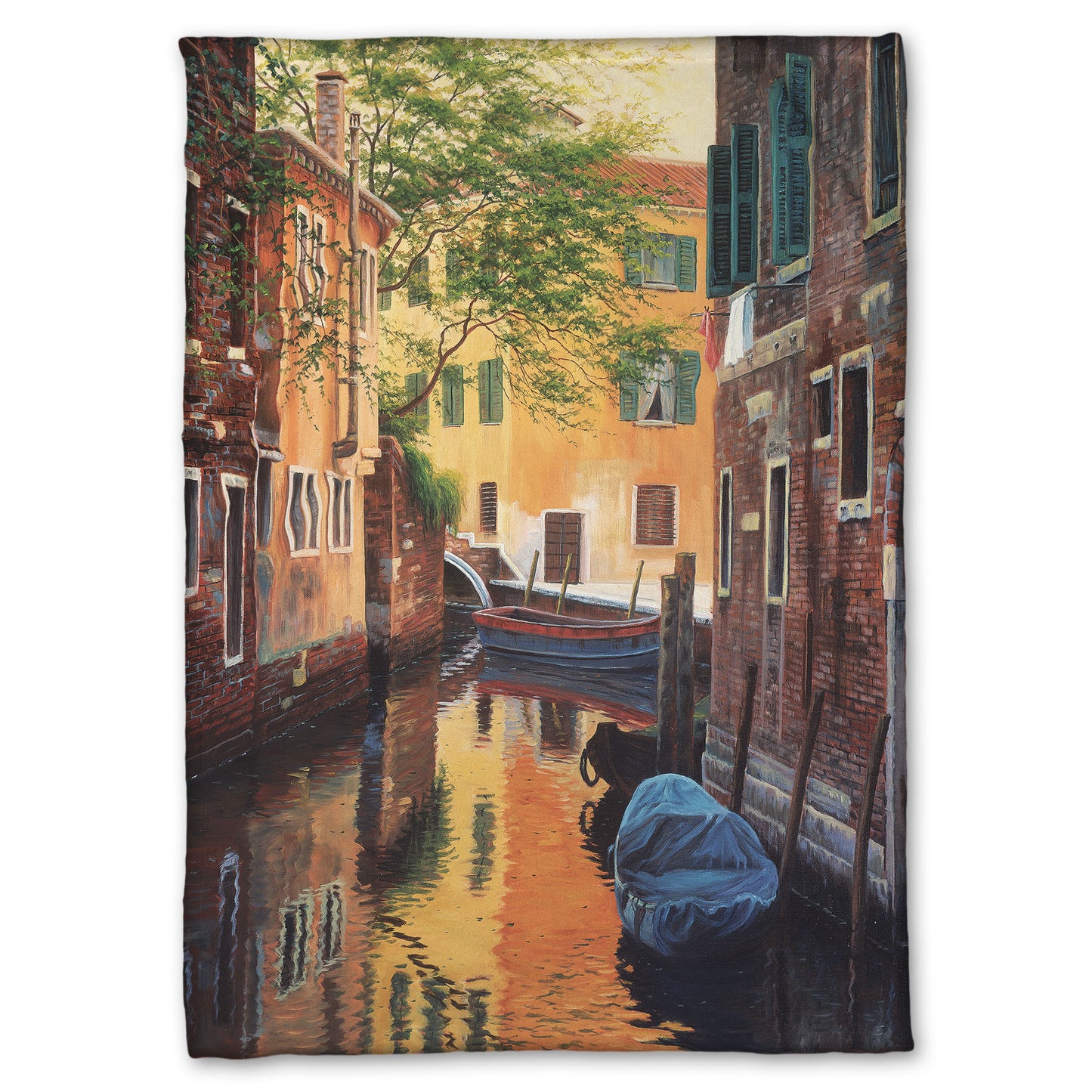 A fleece throw blanket designed with a painting of a canal alleyway between old brick buildings in Venice, Italy, during the day. The buildings reflect off the water in which a few small wood boats float.
