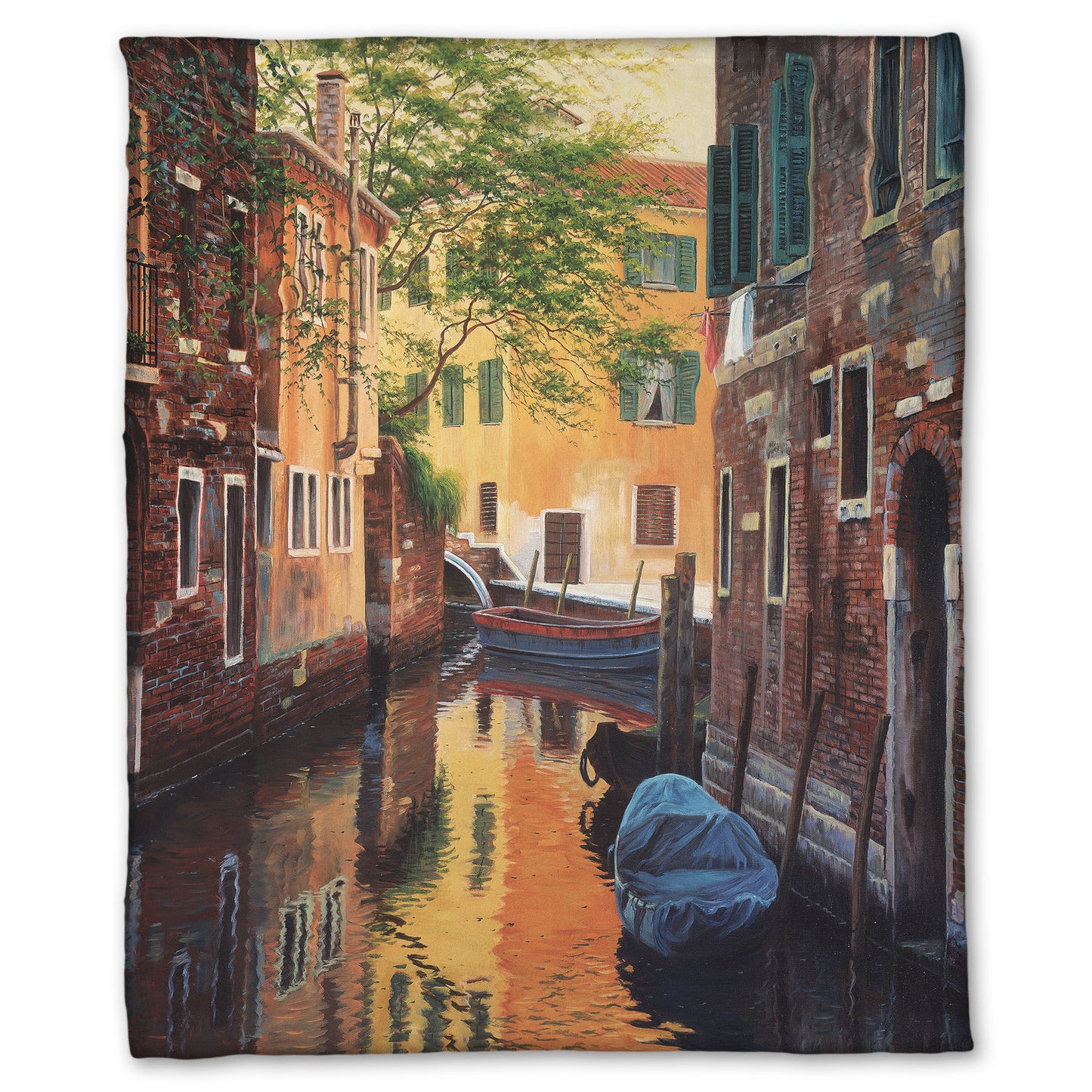 A fleece throw blanket designed with a painting of a canal alleyway between old brick buildings in Venice, Italy, during the day. The buildings reflect off the water in which a few small wood boats float.