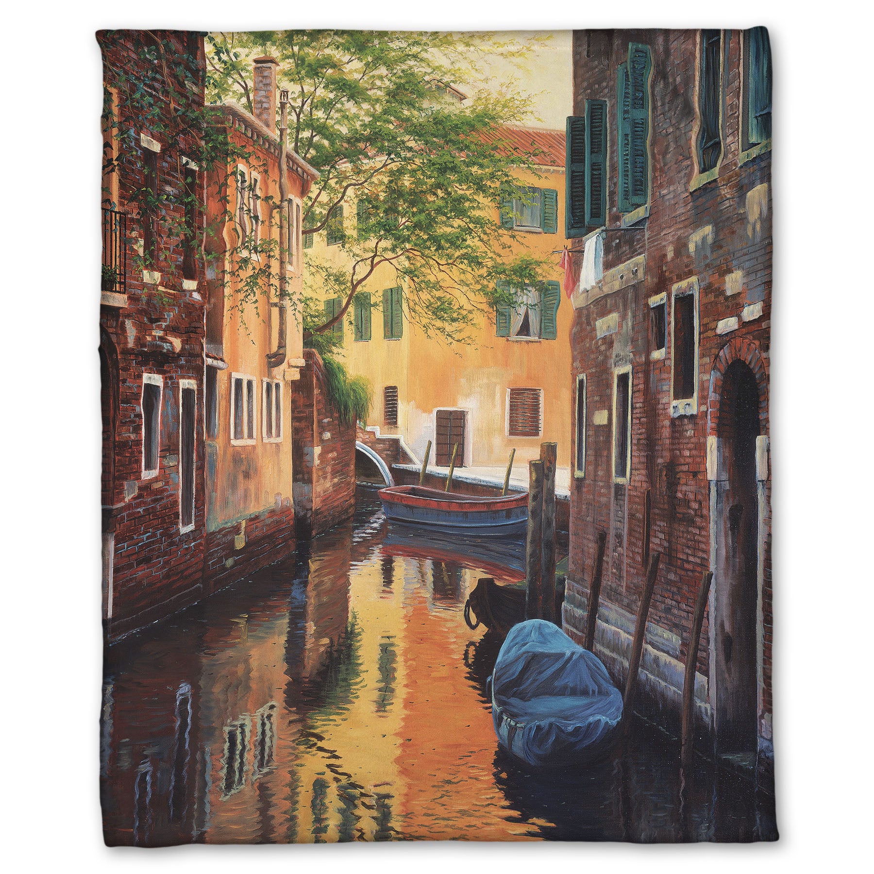 A fleece throw blanket designed with a painting of a canal alleyway between old brick buildings in Venice, Italy, during the day. The buildings reflect off the water in which a few small wood boats float.