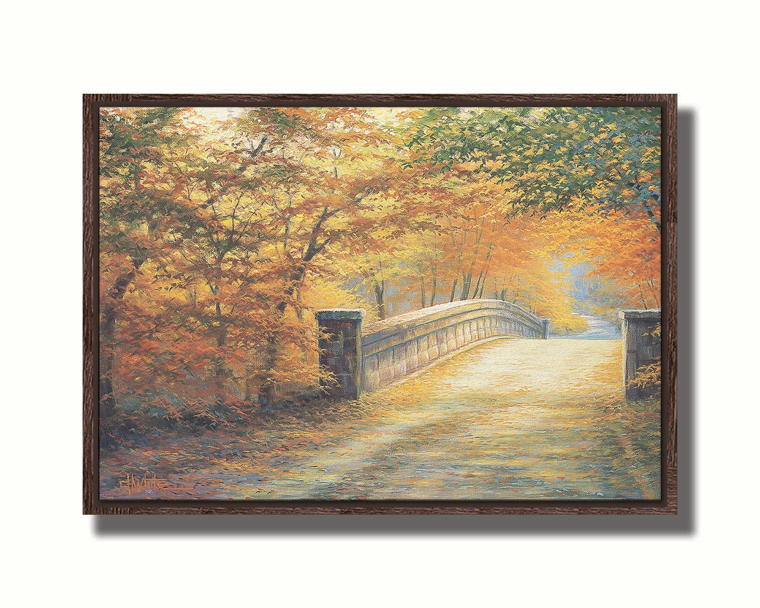 A painting looking down a bridge road during fall. The trees lining the road have turned yellow and orange for autumn, and some of their fallen leaves are scatted along the path. Printed on canvas in a float frame.