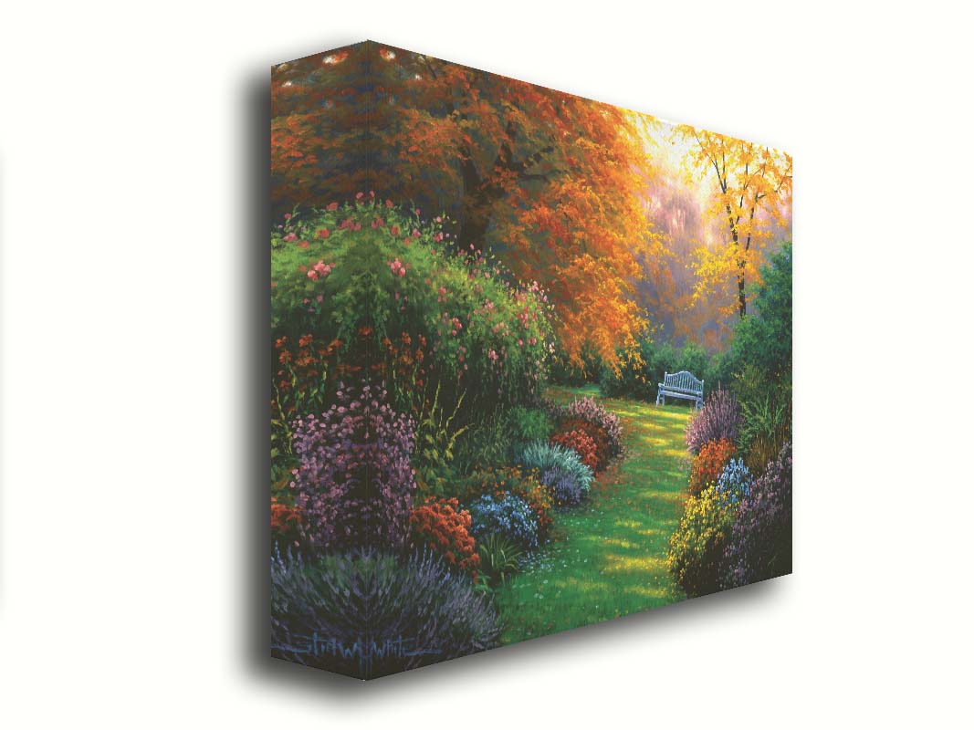 A painting of a garden path during fall. The trees surrounding the garden have turned orange and yellow. A grassy path through the garden is surrounded by bushes of flowers in every color, and a bench can be seen up ahead. Printed on canvas.