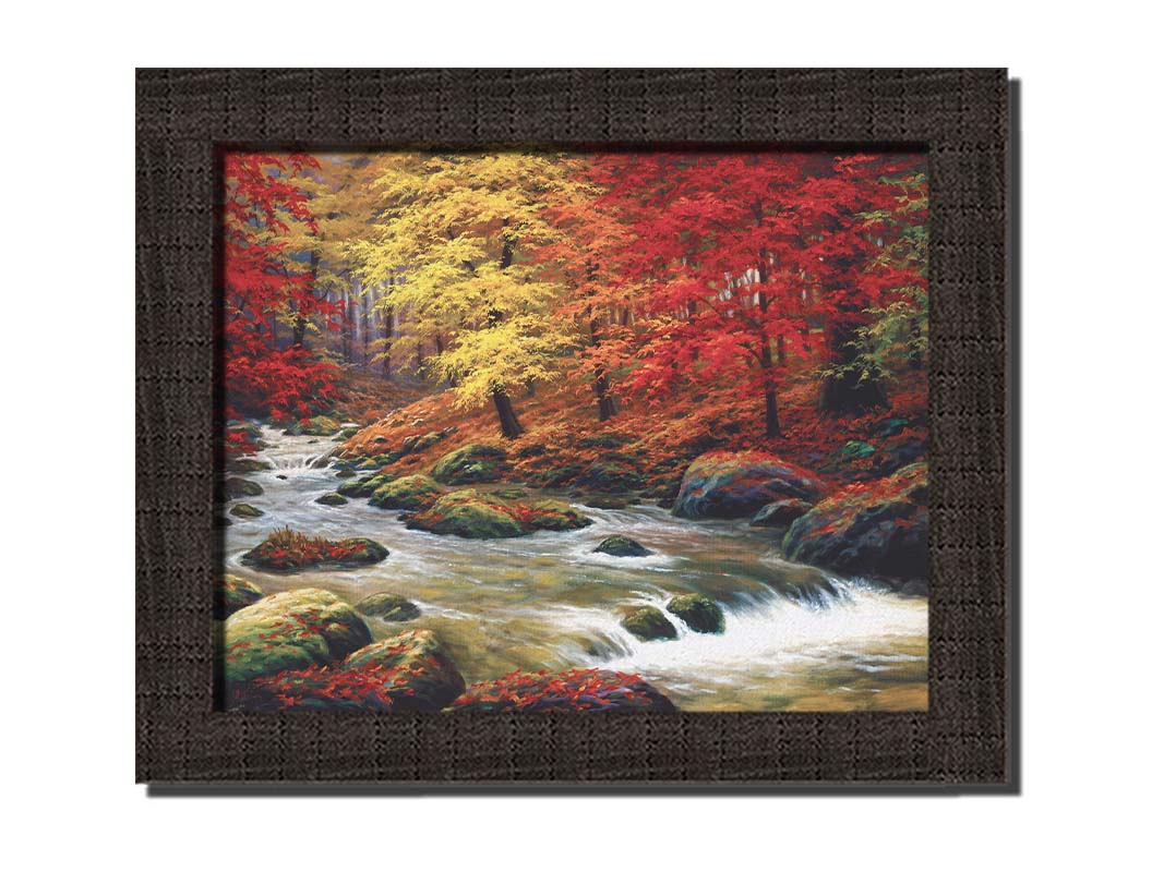 A painting of a river through an autumn forest, with red and yellow trees and an orange, leaf-coated ground. Printed on canvas and framed.