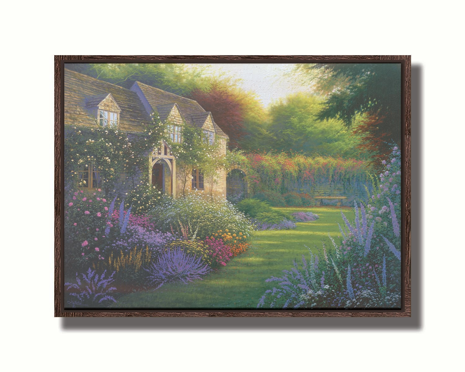 A painting of a blooming garden, with flowers in a variety of pinks, purples, yellows, and whites. A bench site in the grassy clearing beside a cottage, draped in white-flowered vines. Printed on canvas in a float frame.