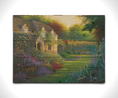 A painting of a blooming garden, with flowers in a variety of pinks, purples, yellows, and whites. A bench site in the grassy clearing beside a cottage, draped in white-flowered vines. Printed on a wood pallet.