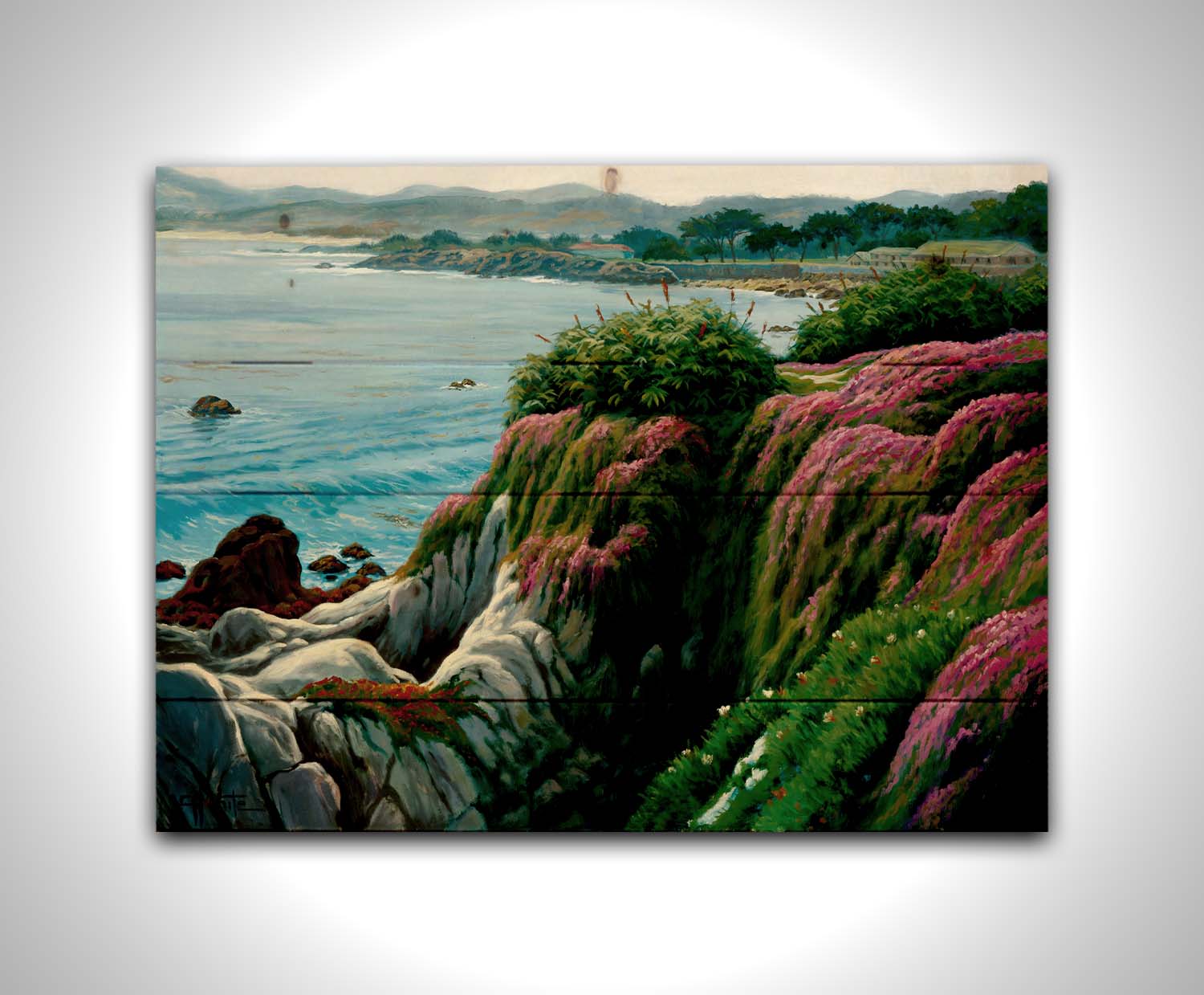 A painting of a clifftop covered in fresh green plants, sprouting pink flowers. Below, the bright blue ocean is calm. Printed on a wood pallet.