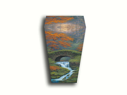 A painting of a creek waterfall, running through a forest. A stone bridge arches over the water. Printed on canvas.