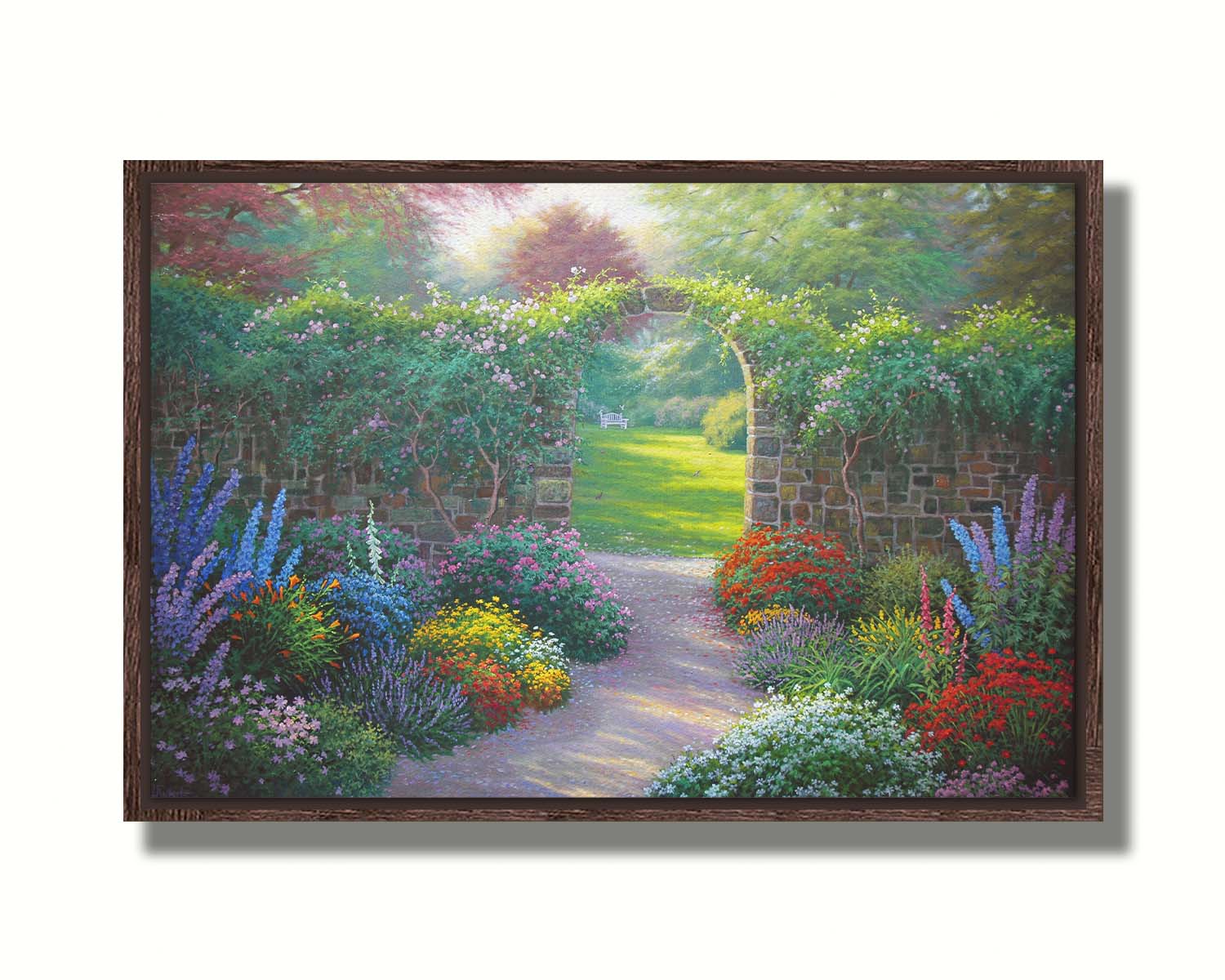 A painting of a stone walled garden with an archway leading to a grassy yard. There are flowers in all colors lining the pathway. Printed on canvas in a float frame.