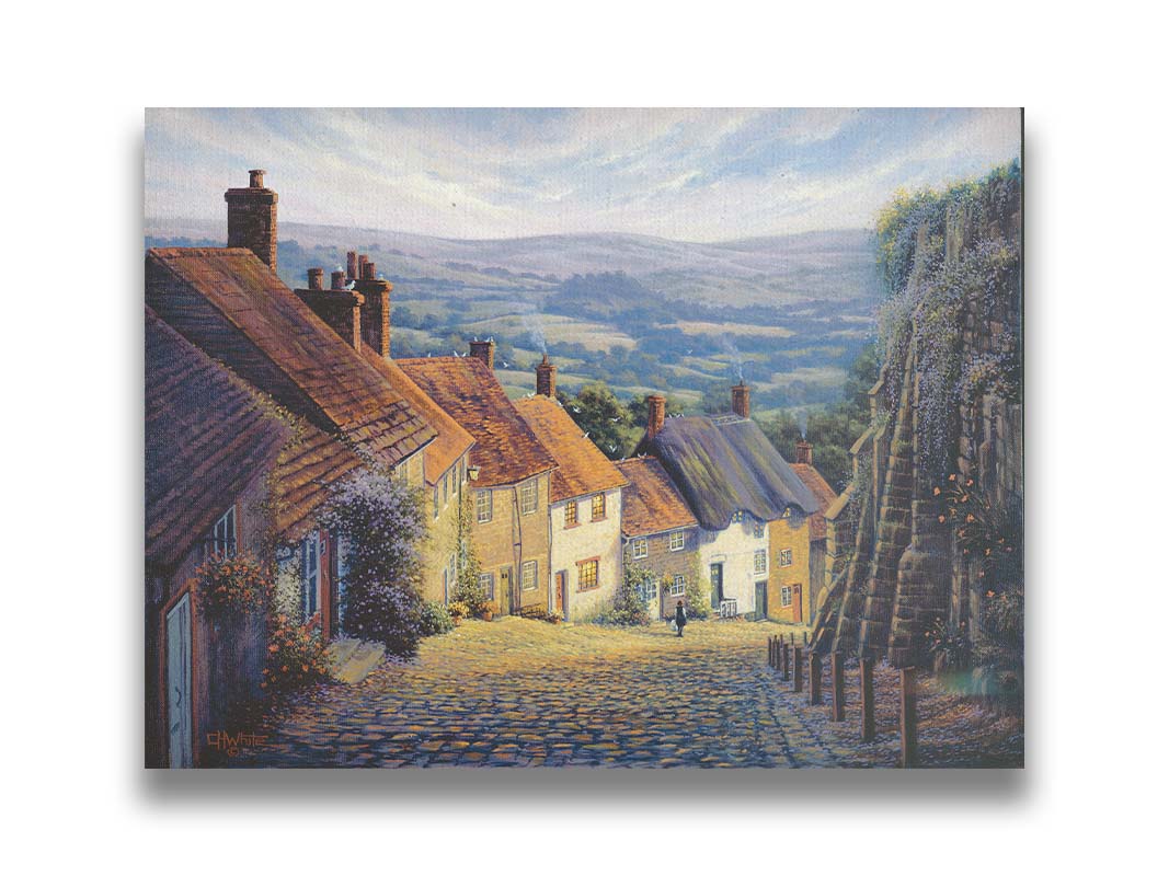 A painting looking down a cobblestone road on a hill lined with houses. A person can be seen walking down the path past flower-laden walls. Printed on canvas.