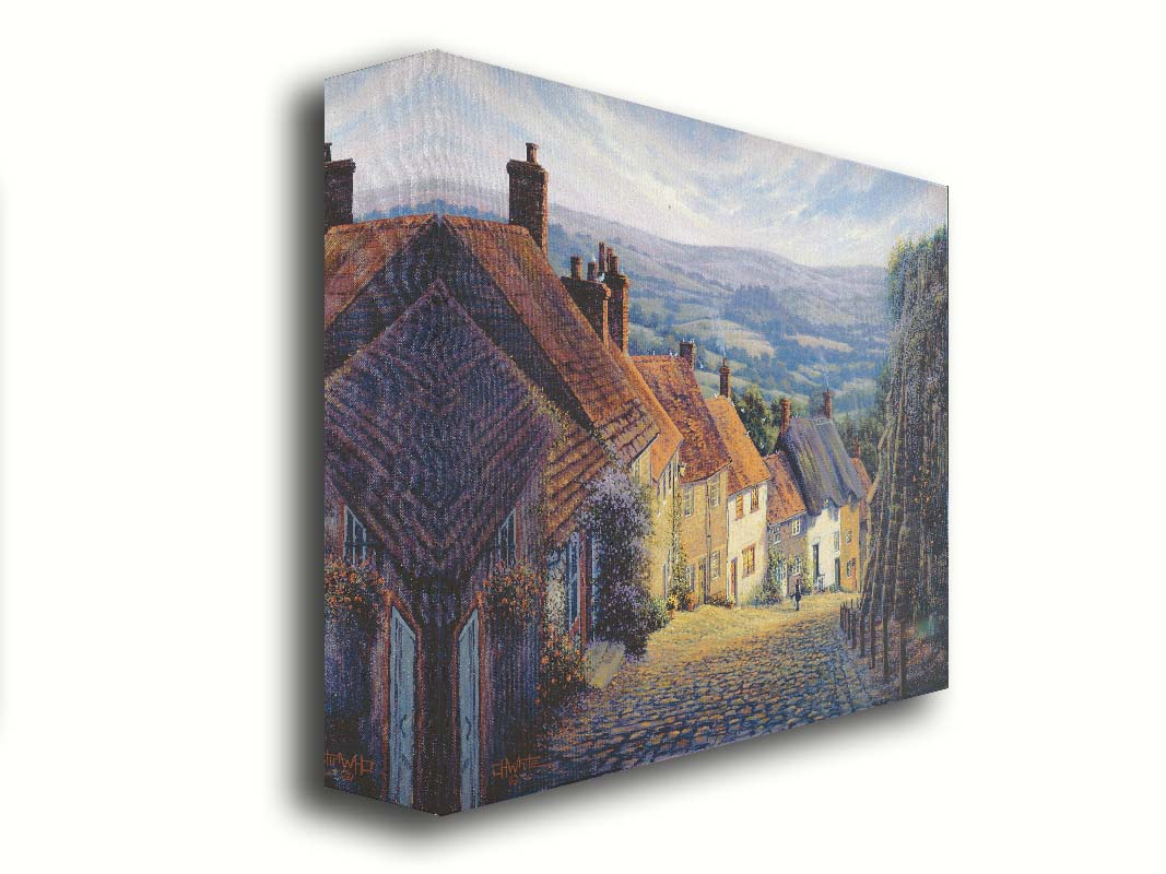 A painting looking down a cobblestone road on a hill lined with houses. A person can be seen walking down the path past flower-laden walls. Printed on canvas.