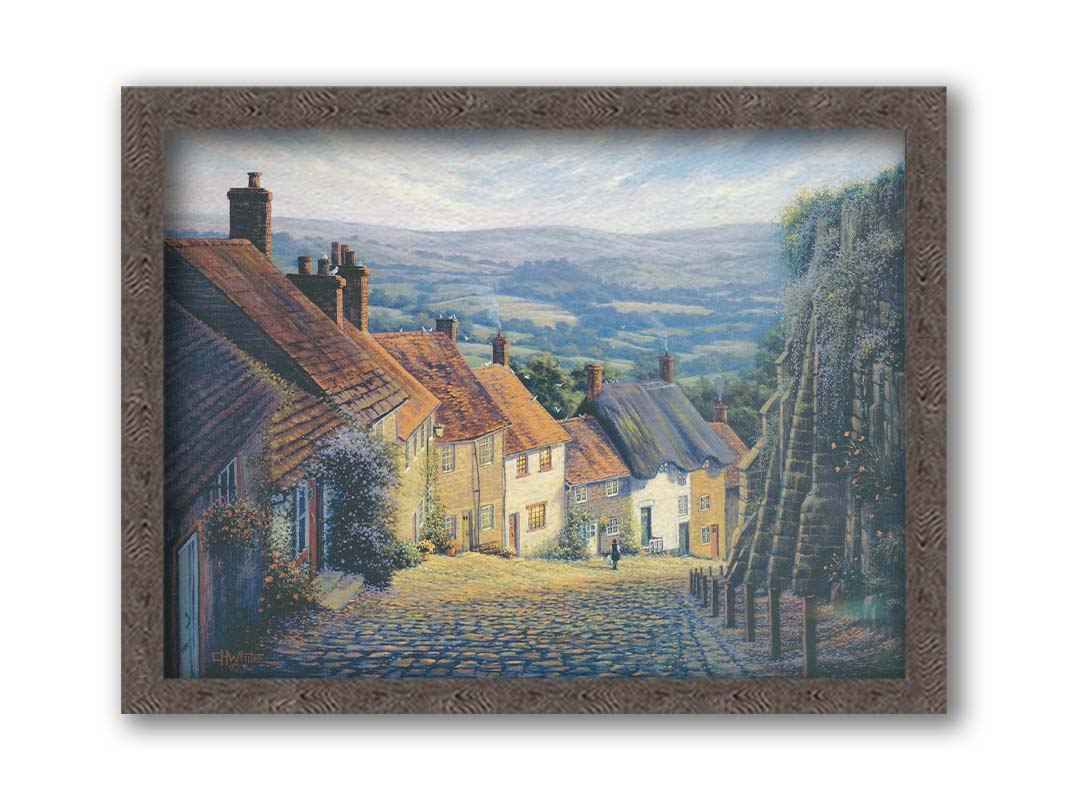 A painting looking down a cobblestone road on a hill lined with houses. A person can be seen walking down the path past flower-laden walls. Printed on canvas and framed.