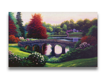 A landscape painting of a lake scene. A stone bridge in the foreground is surrounded by bushes of pink and red flowers, as well as green and red trees. Printed on canvas.