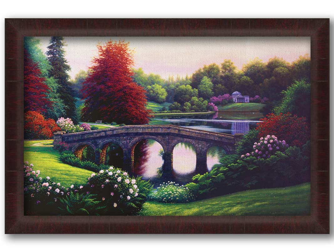 A landscape painting of a lake scene. A stone bridge in the foreground is surrounded by bushes of pink and red flowers, as well as green and red trees. Printed on canvas and framed.