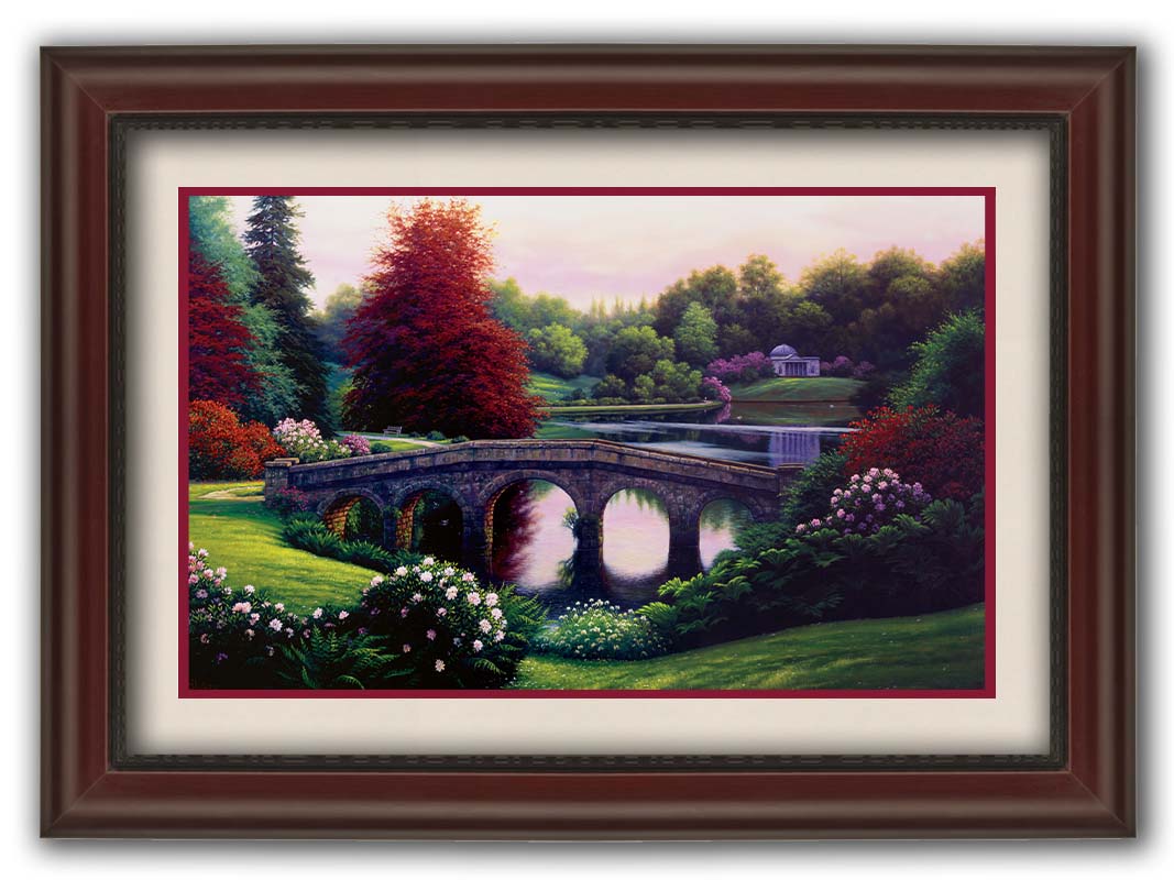 A landscape painting of a lake scene. A stone bridge in the foreground is surrounded by bushes of pink and red flowers, as well as green and red trees. Printed on paper, matted, and framed.