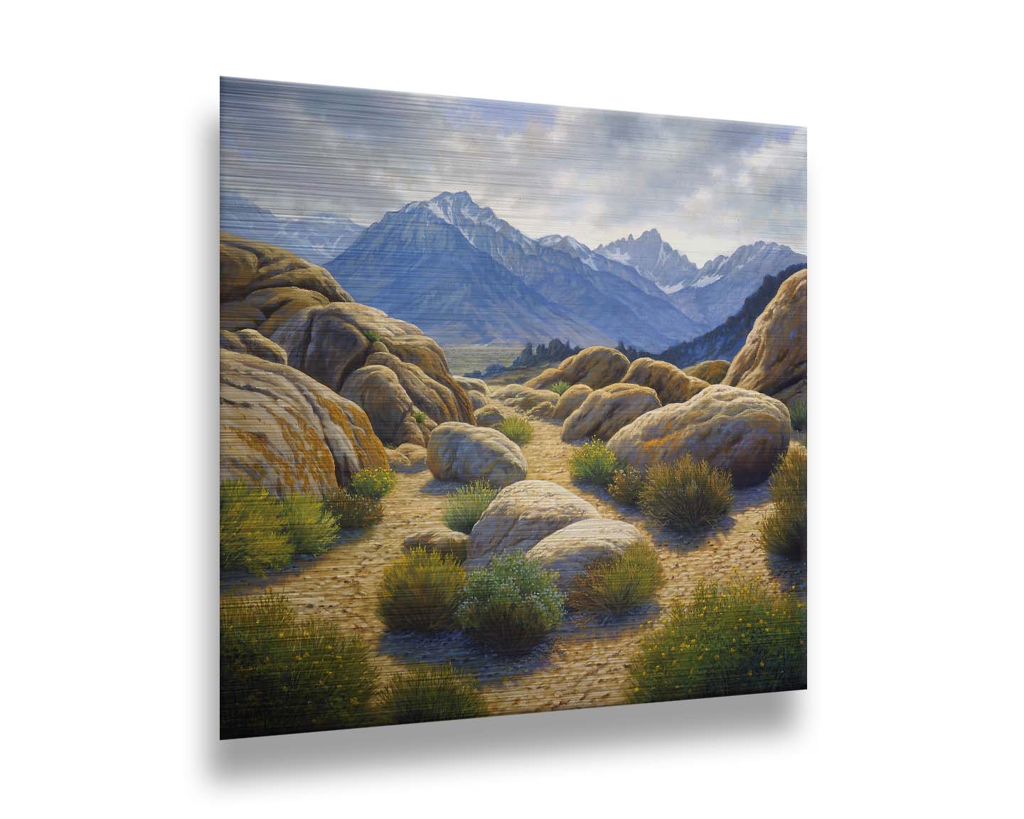 A landscape painting of Mount Whitney as seen from Lone Pine Lake, California. The highly detailed environment of tan stones directs the view to the distant mountains, tinted blue by the atmosphere. Printed on metal.