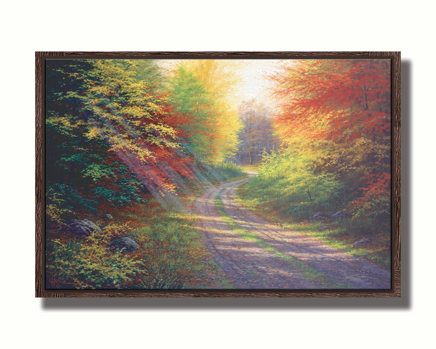 A landscape painting of a gravel road winding thorugh an autumn forest with a mix of vibrant red, yellow, and green leaves. Printed on canvas in a float frame.