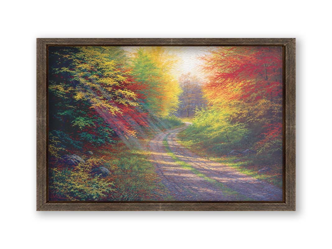 A landscape painting of a gravel road winding thorugh an autumn forest with a mix of vibrant red, yellow, and green leaves. Printed on canvas and framed.