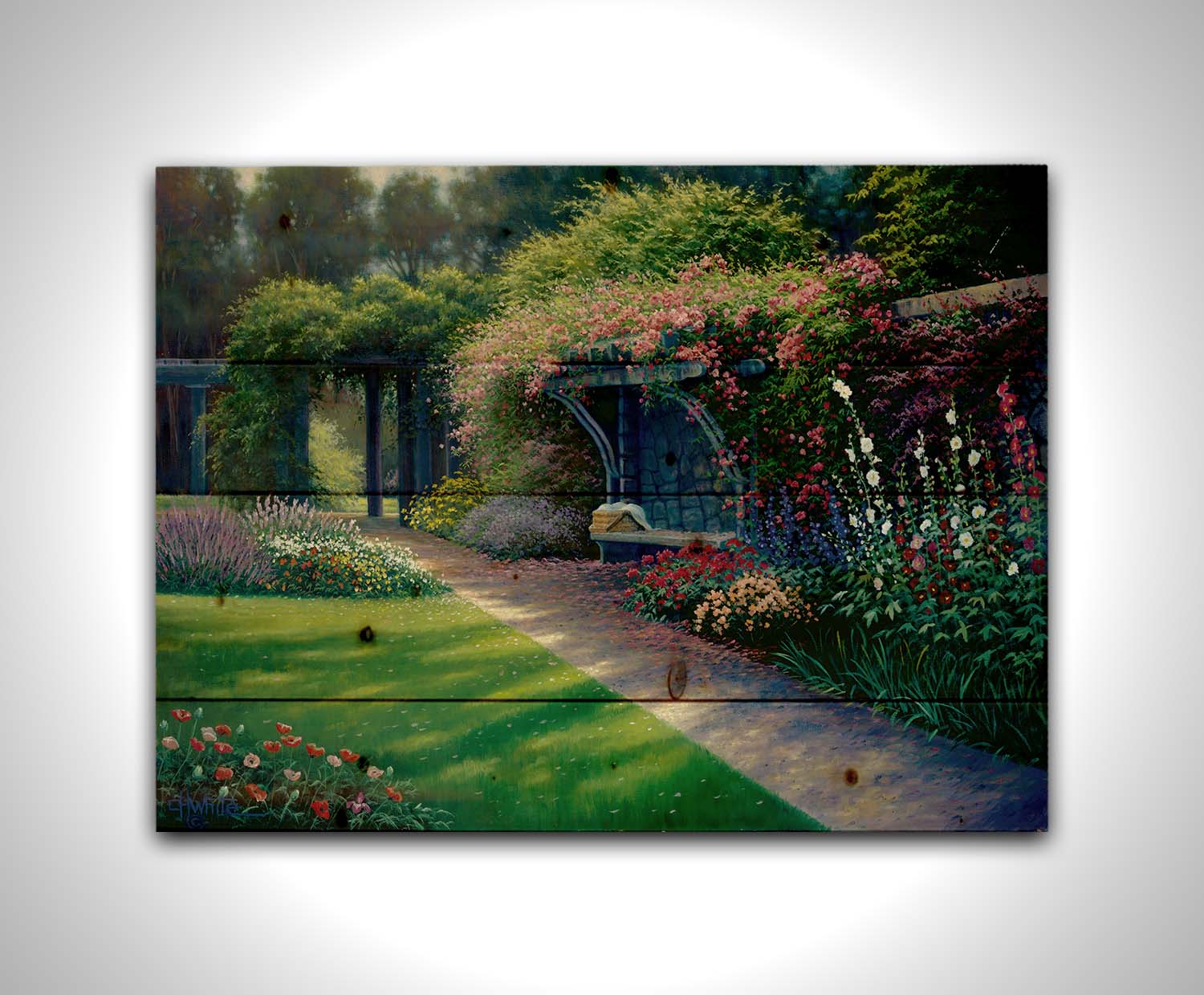 A painting of the Hatley Park Garden at Royal Roads University, overlooking a path surrouded by flowering plants. A bench with a picnic basket sits on the path against a stone wall. Printed on a wood pallet.