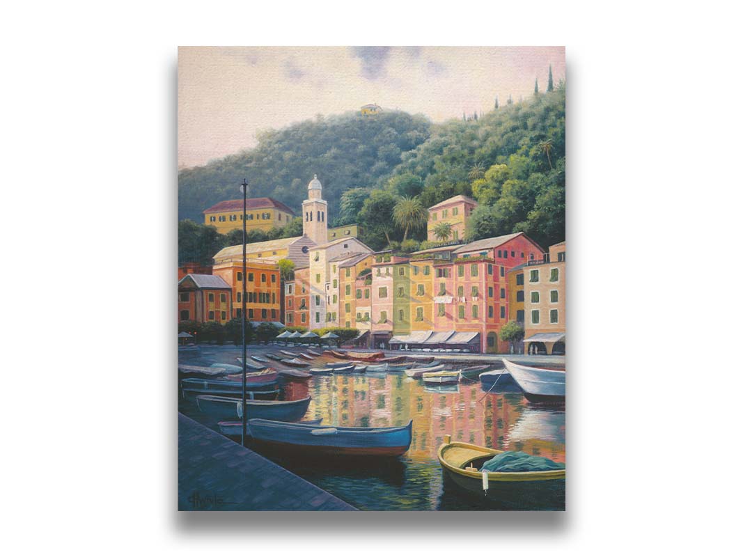 A painting of the colorful fishing town of Portofino. Many small boats are docked in the waters in the foreground, and the steep hills in the background are lush with trees. Printed on canvas.