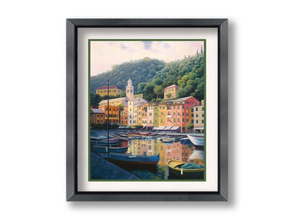 A painting of the colorful fishing town of Portofino. Many small boats are docked in the waters in the foreground, and the steep hills in the background are lush with trees. Printed on paper, matted, and framed.