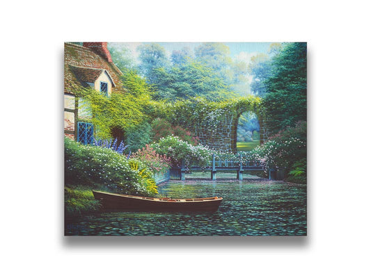 A painting of a canoe docked in a river covered in lily pads. A flower-covered bridge crosses the river, leading to a house coated in vines. A stone arched wall leads to another section of the garden in the background. Printed on canvas.