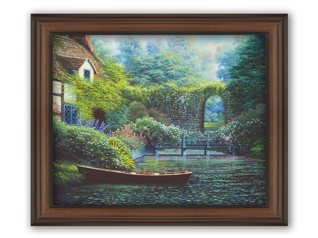 A painting of a canoe docked in a river covered in lily pads. A flower-covered bridge crosses the river, leading to a house coated in vines. A stone arched wall leads to another section of the garden in the background. Printed on canvas and framed.