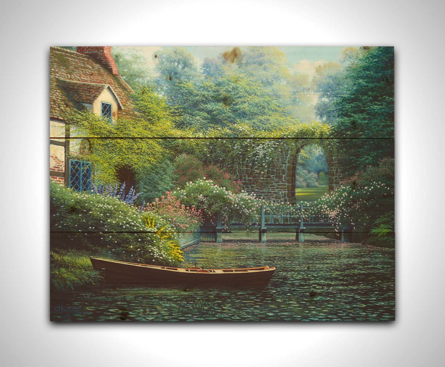 A painting of a canoe docked in a river covered in lily pads. A flower-covered bridge crosses the river, leading to a house coated in vines. A stone arched wall leads to another section of the garden in the background. Printed on a wood pallet.