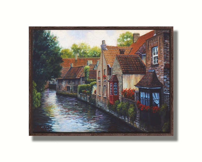 A painting of the Bruges Canal in Belgium, lined by brick homes with red and brown tlie roofs. Red flowers and a red bay window pop in the scene. Printed on canvas in a float frame.