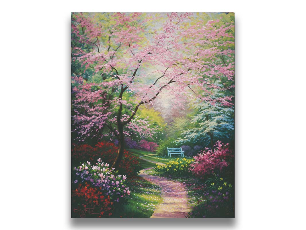 A painting of a garden in spring, with pink, red, and white blossoms on the bushes and trees. Pink petals fall from a tree by the narrow path, piling on the ground. A park bench can be seen in the distance. Printed on canvas.