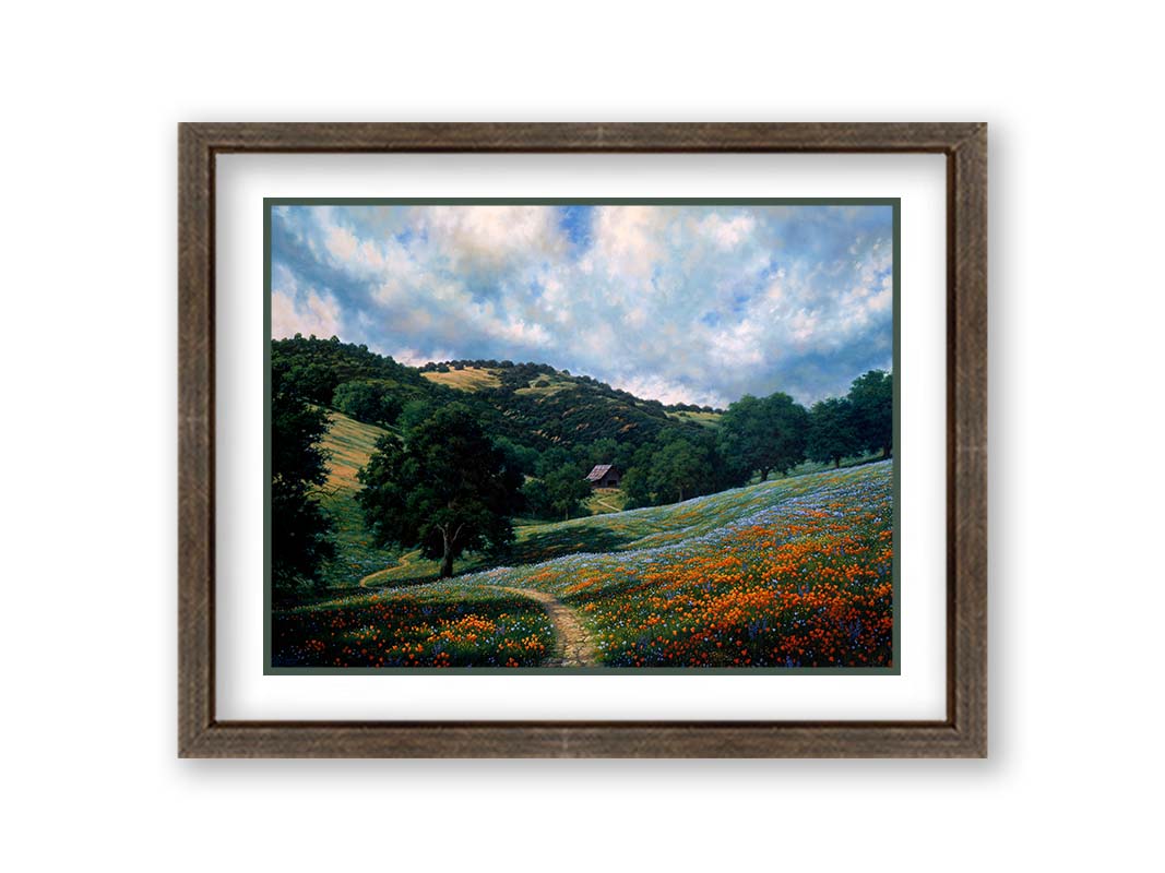 A painting of a hillside meadow of orange and blue flowers. A thin dirt path cuts through the meadow, leading to an old barn in the distance. Printed on paper, matted, and framed.