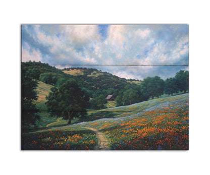 A painting of a hillside meadow of orange and blue flowers. A thin dirt path cuts through the meadow, leading to an old barn in the distance. Printed on a box board.