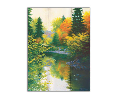 A painting of tranquil water reflecting a forest of orange, yellow, and green trees. A few ducks can be seen swimming on the water. Printed on a box board.