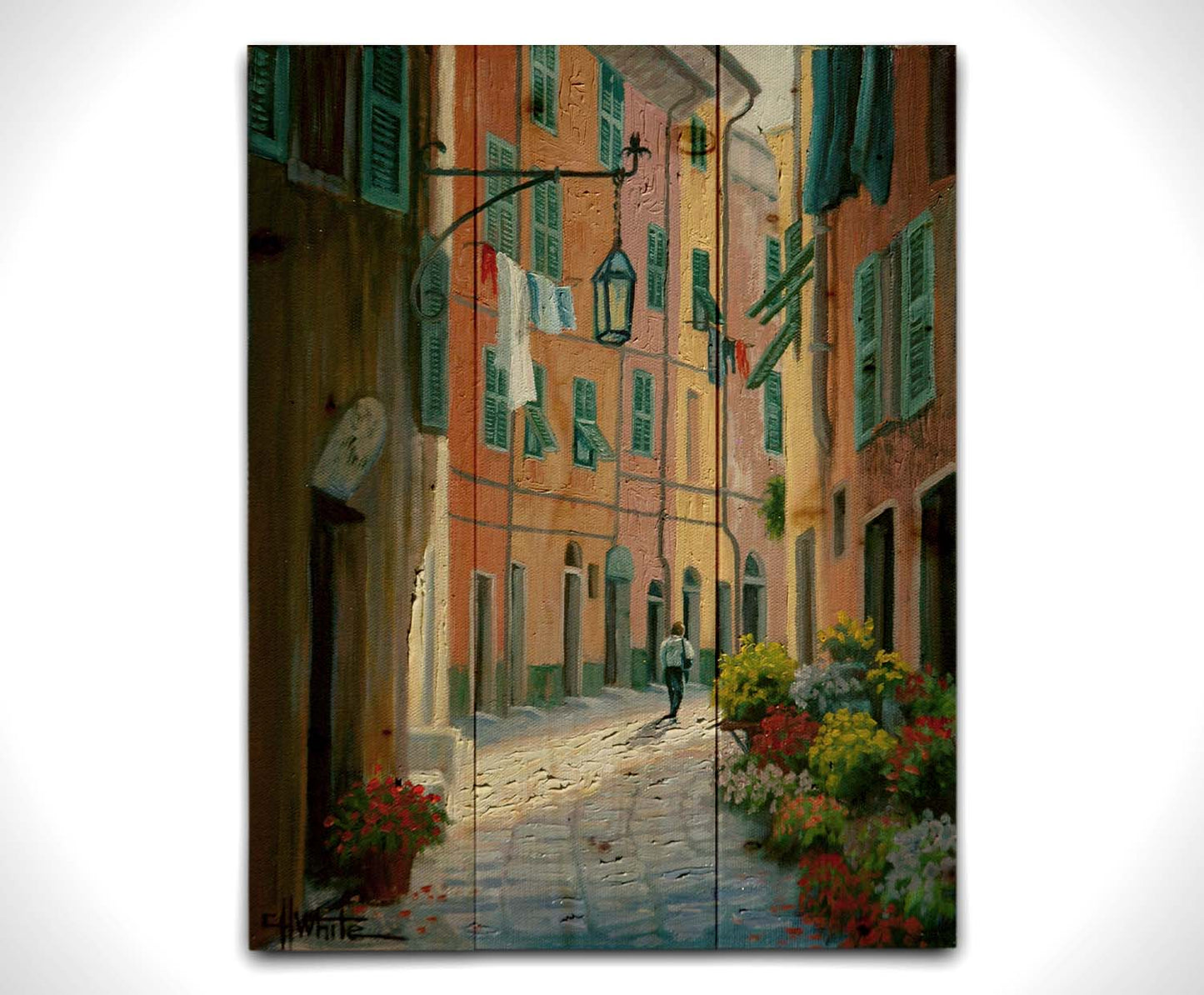 A painting of a stone path through Portofino, Italy. Warm-colored building line the road, clothes hanging from their window lines. Potted flowers grow at the doorsteps. Printed on a wood pallet.