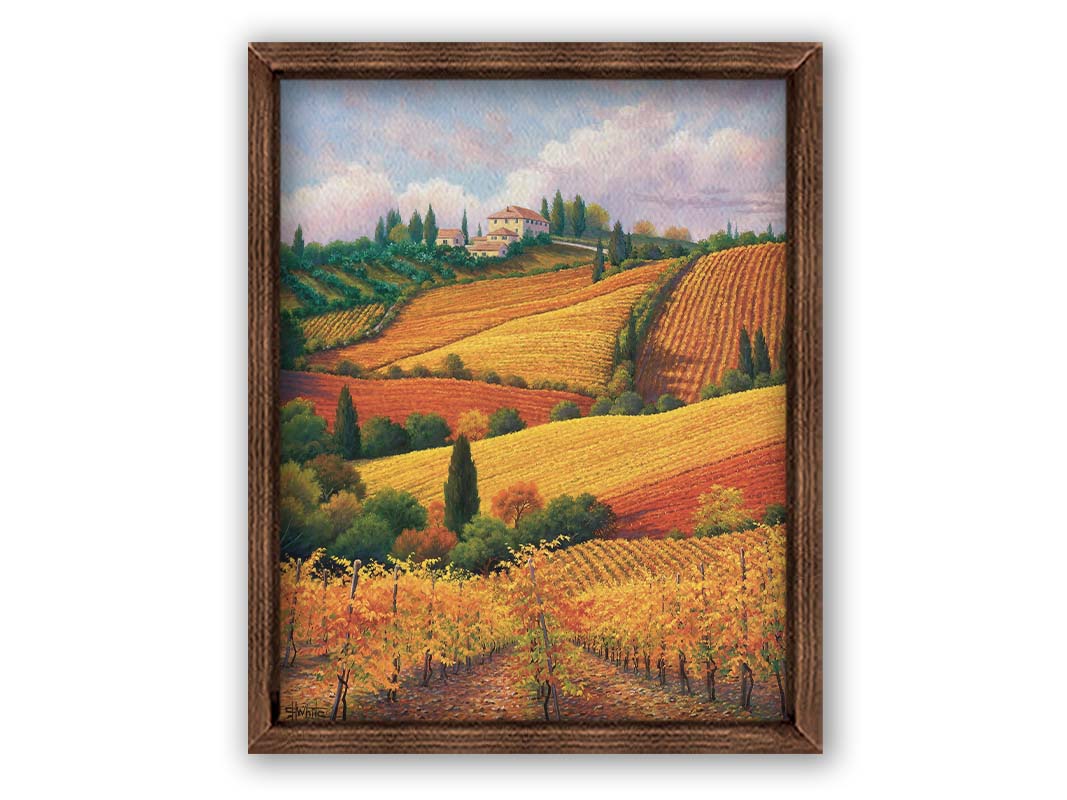 A painting of the Tuscany countryside. All the visible land has been turned eto crop fields, with rows of grape vines in the foreground. On the hills in the distance site a series of white buildings. Printed on canvas and framed.