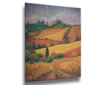 A painting of the Tuscany countryside. All the visible land has been turned eto crop fields, with rows of grape vines in the foreground. On the hills in the distance site a series of white buildings. Printed on metal.