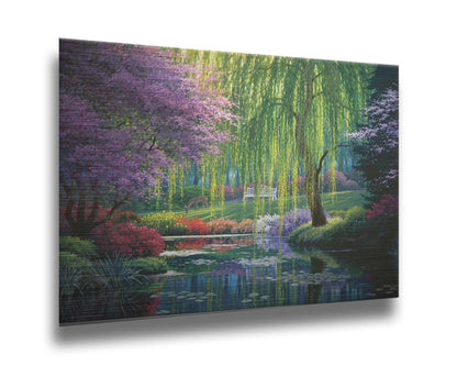 A painting of a garden pont, reflecting the surrounding scenery. Trees blossoming in pink grow with willows alonside the pond, as well as bushes of flowers in pink, red, yellow, white, and purple. Deer graze on the grass in the background, in a clearing with a white bench. Printed on metal.