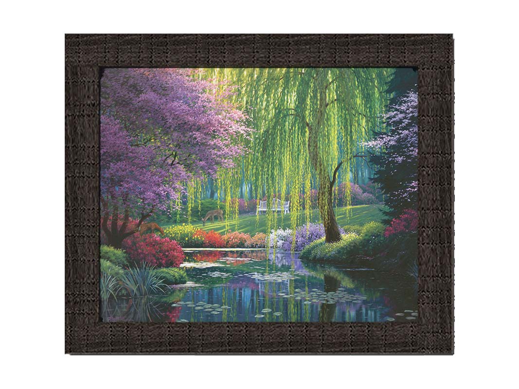 A painting of a garden pont, reflecting the surrounding scenery. Trees blossoming in pink grow with willows alonside the pond, as well as bushes of flowers in pink, red, yellow, white, and purple. Deer graze on the grass in the background, in a clearing with a white bench. Printed on canvas and framed.