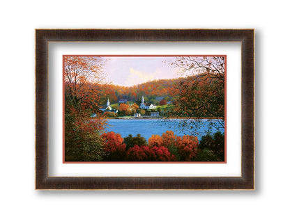 A painting of a small lakeside town, surrounded by an autumn forest. Orange and red leaves contrast green grass and vibrant blue water. Printed on paper, matted, and framed.