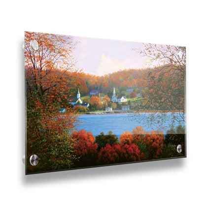 A painting of a small lakeside town, surrounded by an autumn forest. Orange and red leaves contrast green grass and vibrant blue water. Printed on acrylic.