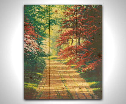 A painting of a dirt path through a spring woodland. Vibrant green trees grow alongside red japanese maples and pink and white blossoms. Printed on a wood pallet.