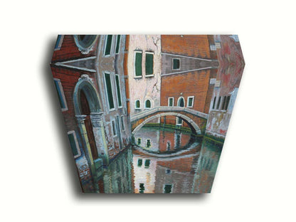 A painting of a Venice canal alleyway, passing under a bridge between old brick buildings. Printed on canvas.