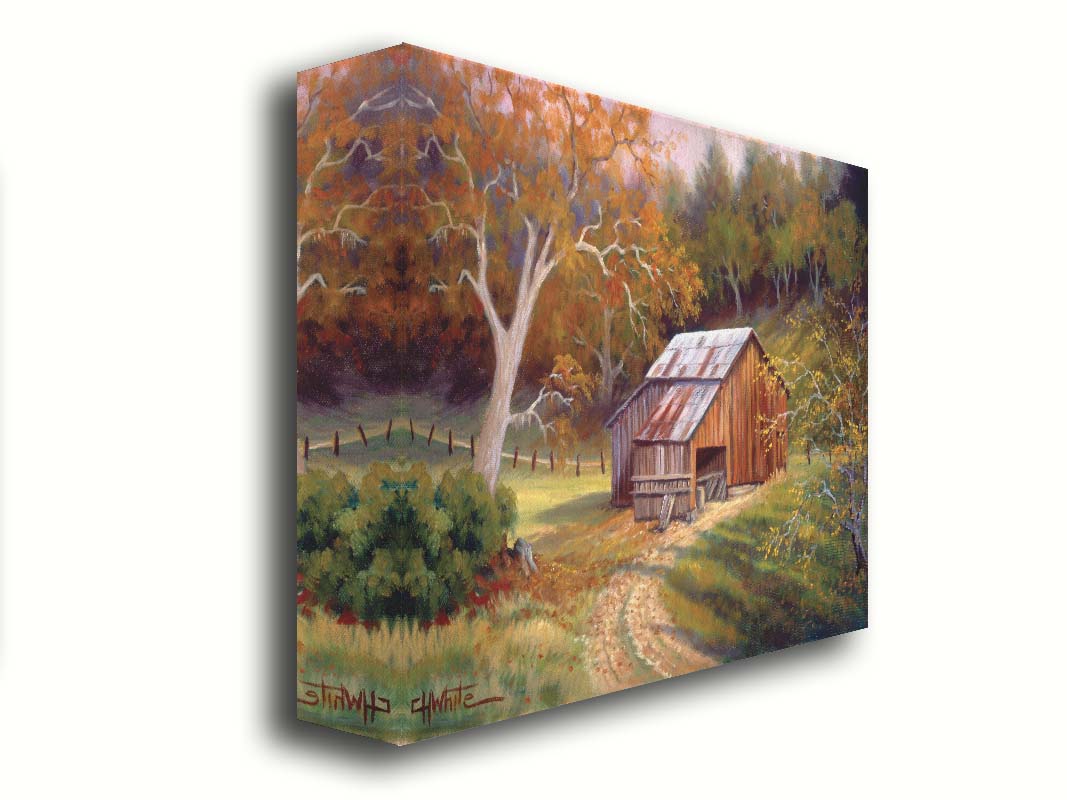 A painting of a dirt road near a forest, leading toward a rustic old barn. The leaves of the trees are turning colors for fall. Printed on canvas.