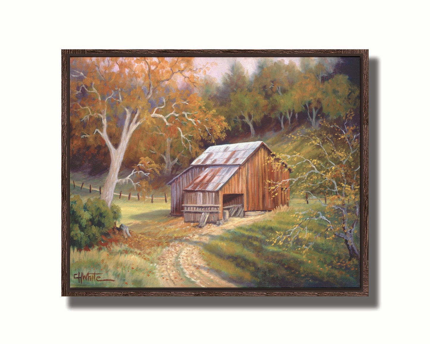 A painting of a dirt road near a forest, leading toward a rustic old barn. The leaves of the trees are turning colors for fall. Printed on canvas in a float frame.