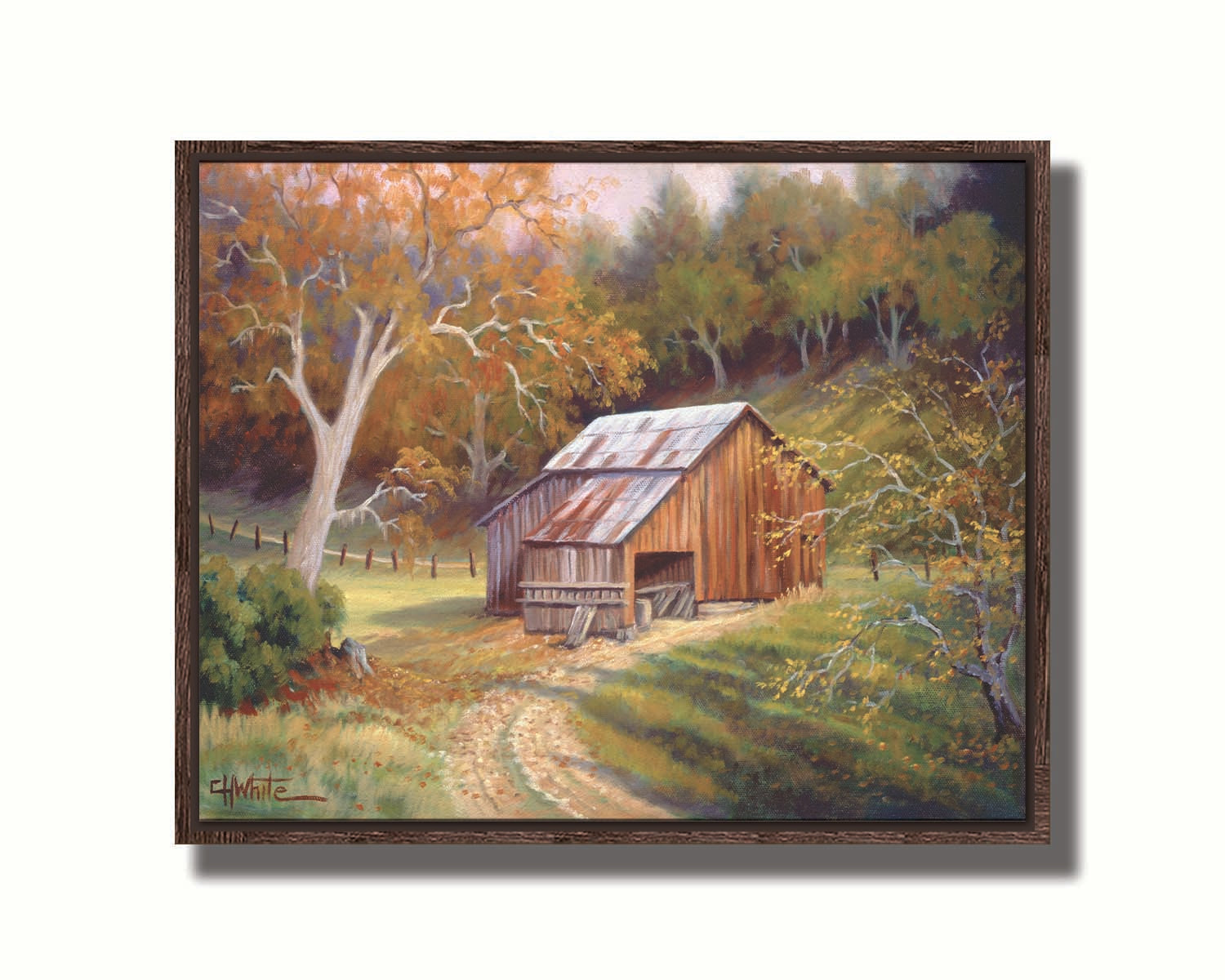 A painting of a dirt road near a forest, leading toward a rustic old barn. The leaves of the trees are turning colors for fall. Printed on canvas in a float frame.