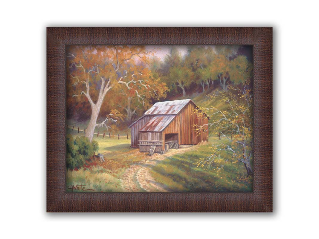 A painting of a dirt road near a forest, leading toward a rustic old barn. The leaves of the trees are turning colors for fall. Printed on canvas and framed.