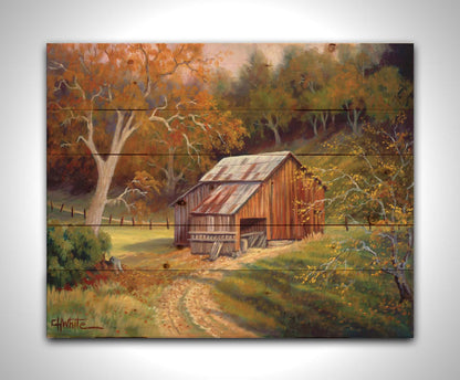 A painting of a dirt road near a forest, leading toward a rustic old barn. The leaves of the trees are turning colors for fall. Printed on a wood pallet.