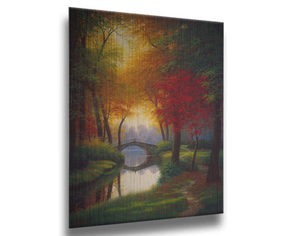 A painting of a path through a forested park in autumn, running alongside a stream to a bridge. Printed on metal.